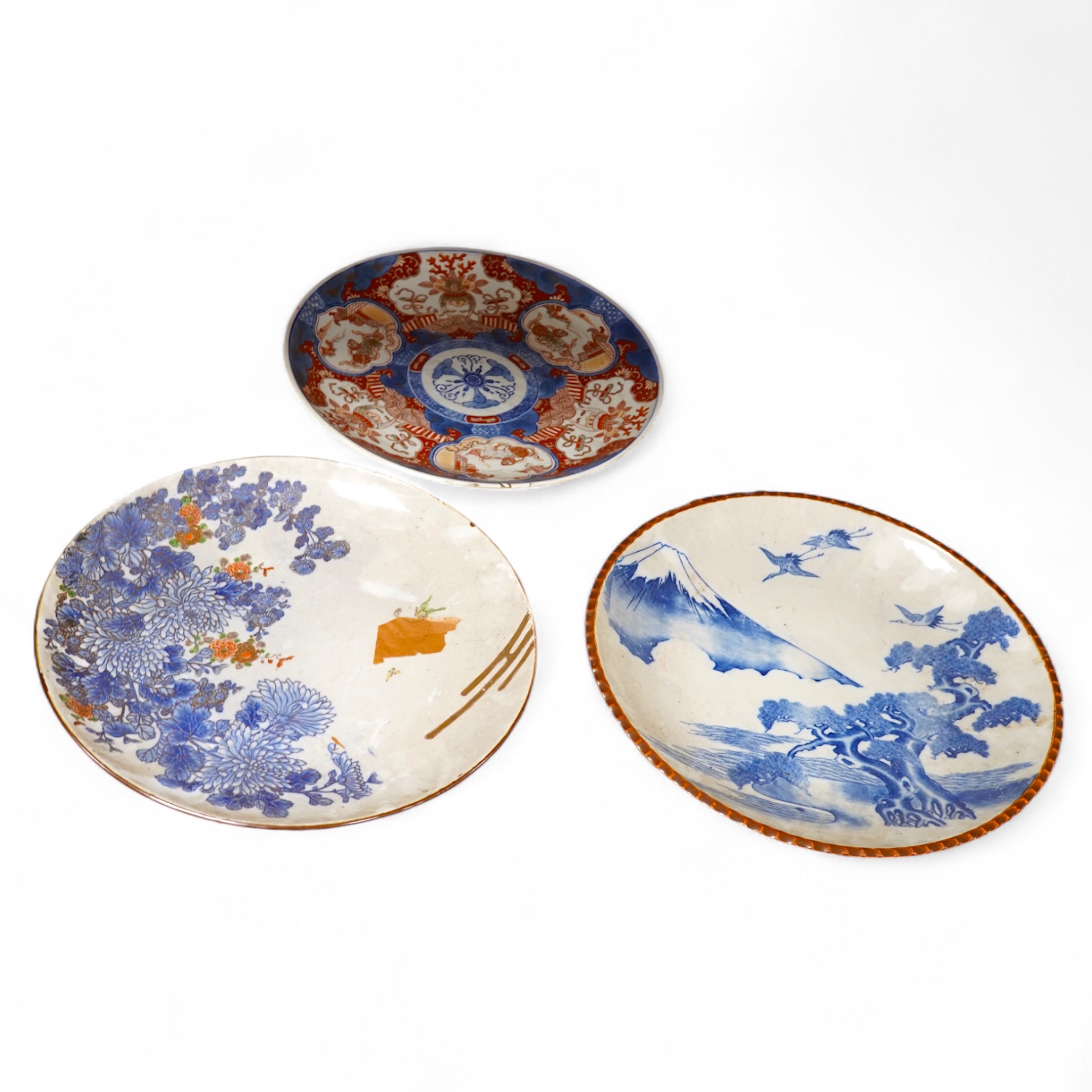 Three large Japanese dishes or chargers to include an Imari pattern example and one depicting Mount Fuji, largest 40cm in diameter